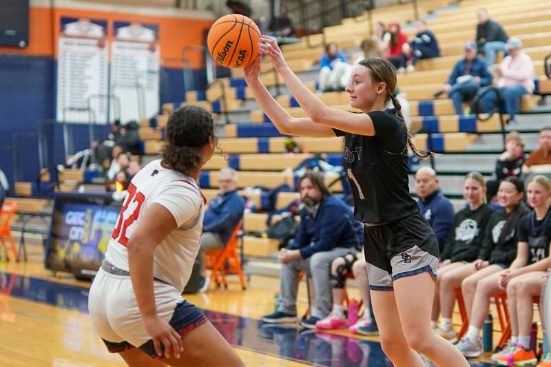 Oswego East's Aubrey Lamberti (1) passes the ball against Oswego’s Ahlivia East (32) during a basketball game at Oswego High School on Wednesday, January 22, 2025.