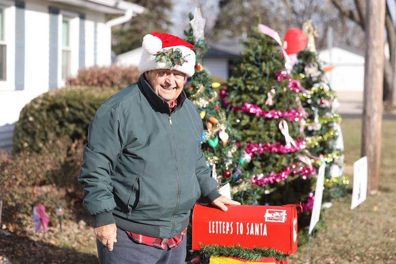 Sam Chellino stands by his three Christmas tree, where he encourages people to place ornaments on for lost loved ones, cancer survivors and making a holiday wish on Friday, Dec. 13, 2024 in Joliet.