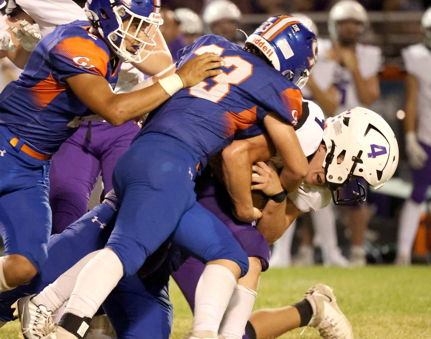 Dixon's Landon Knigge pushes for extra yardage as Genoa-Kingston's Tyler Atterberry (left) and Owen Zaccard make the tackle during their game Friday, Sept. 20, 2024, at Genoa-Kingston High School.