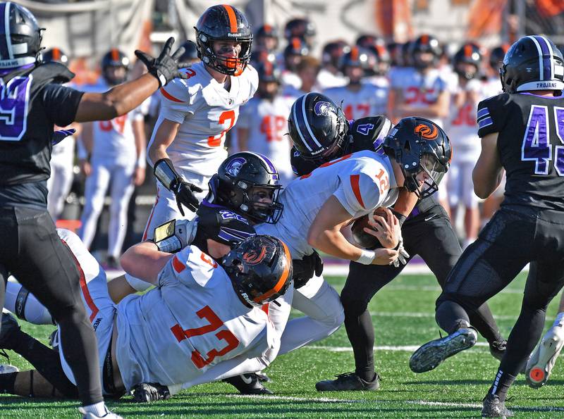 Downers Grove North’s Caden Chiarelli (4) and Joe Lasota  (22) stop Lincoln-Way West quarterback Grant Tustin (12) during a Class 7A quarterfinal game on November 15, 2025 at Downers Grove North High School in Downers Grove .