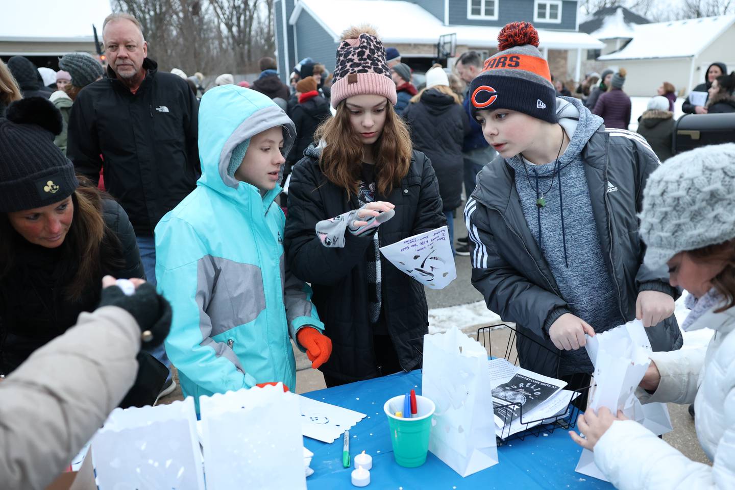 Talia Carver (center), a student of Lynn Smith, writes words of encouragement on a lantern for her teacher along with her friend Libby Atwook and brother Gavin. Hundreds came out to show support as Lynn Smith is battling cancer.
