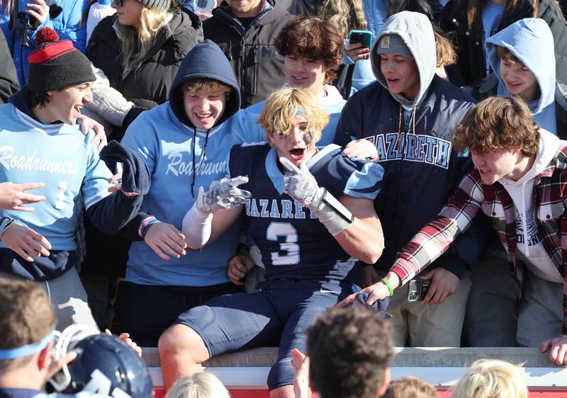Nazareth's Jaden Fauske jumps into the stands to celebrate with fans Saturday, Nov. 25, 2023, after their IHSA Class 5A state championship win over Joliet Catholic Hancock Stadium at Illinois State University in Normal.