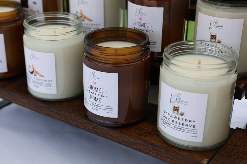 A variety of scented candles sits on display at the Klima Candle Co. tent at the new city square for the farmers market on Friday, May 22, 2026 in Joliet.