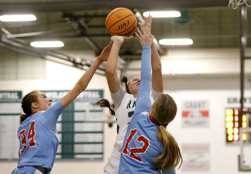 Grayslake Central's Madison Hoffmann shoots the ball between Marian Central's Juliette Huff (left) and Abbey Miner (right) during a nonconference girls basketball on Monday, Jan. 13, 2025, at Grayslake Central High School.