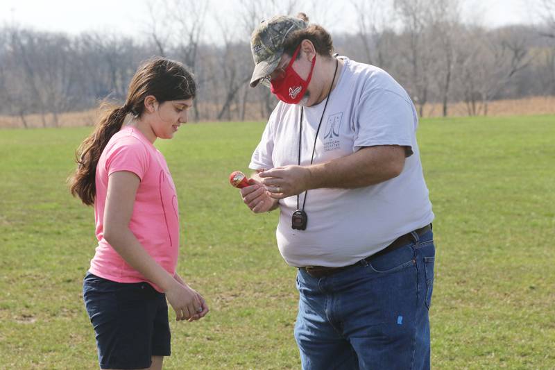 Rosa Lozano, 10, of Lake Villa, a member of the Prince of Peace Redhawk Rocketeers Team, gets some help from Bob Zurek, of Antioch, advisor, analyzing the eggloft rocket she built after it just launched at the Tim Osmond Sports Complex in Antioch.