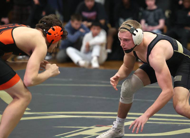 Sycamore’s Cooper Bode (right) wrestles DeKalb’s Ben Charbonneau at 165 pounds during their match Friday, Jan. 16, 2026, at Sycamore High School.