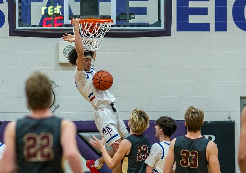 Marmion's Jabe Haith (2) dunks the ball against Morris’ Jack Wheeler (23) during the 59th Annual Plano Christmas Classic basketball tournament at Plano High School on Tuesday, Dec 27, 2022.