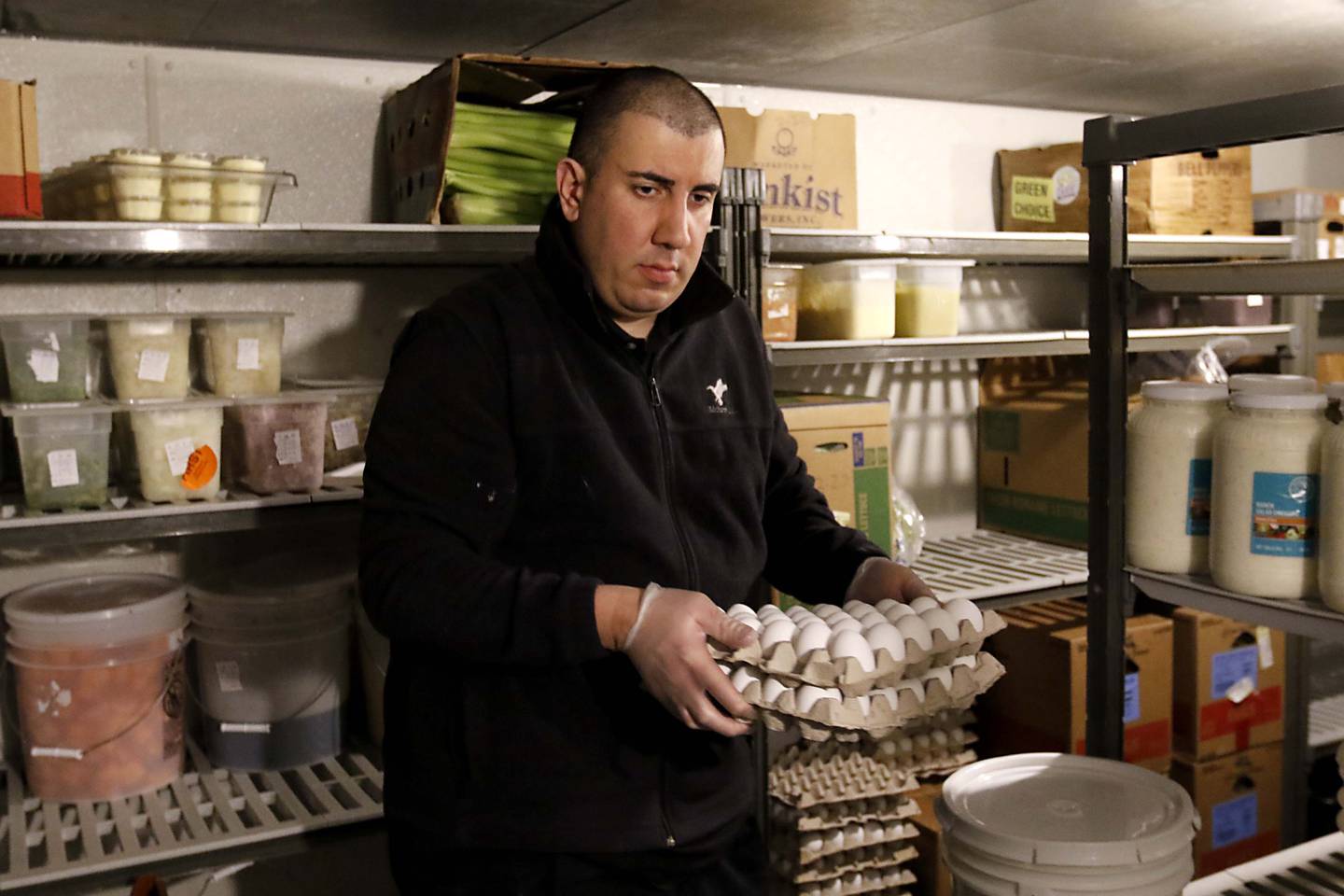 Angelo Angelos carries a container of eggs out of the cooler on Friday, March 21, 2025, at Andy's Restaurant, in Crystal Lake.