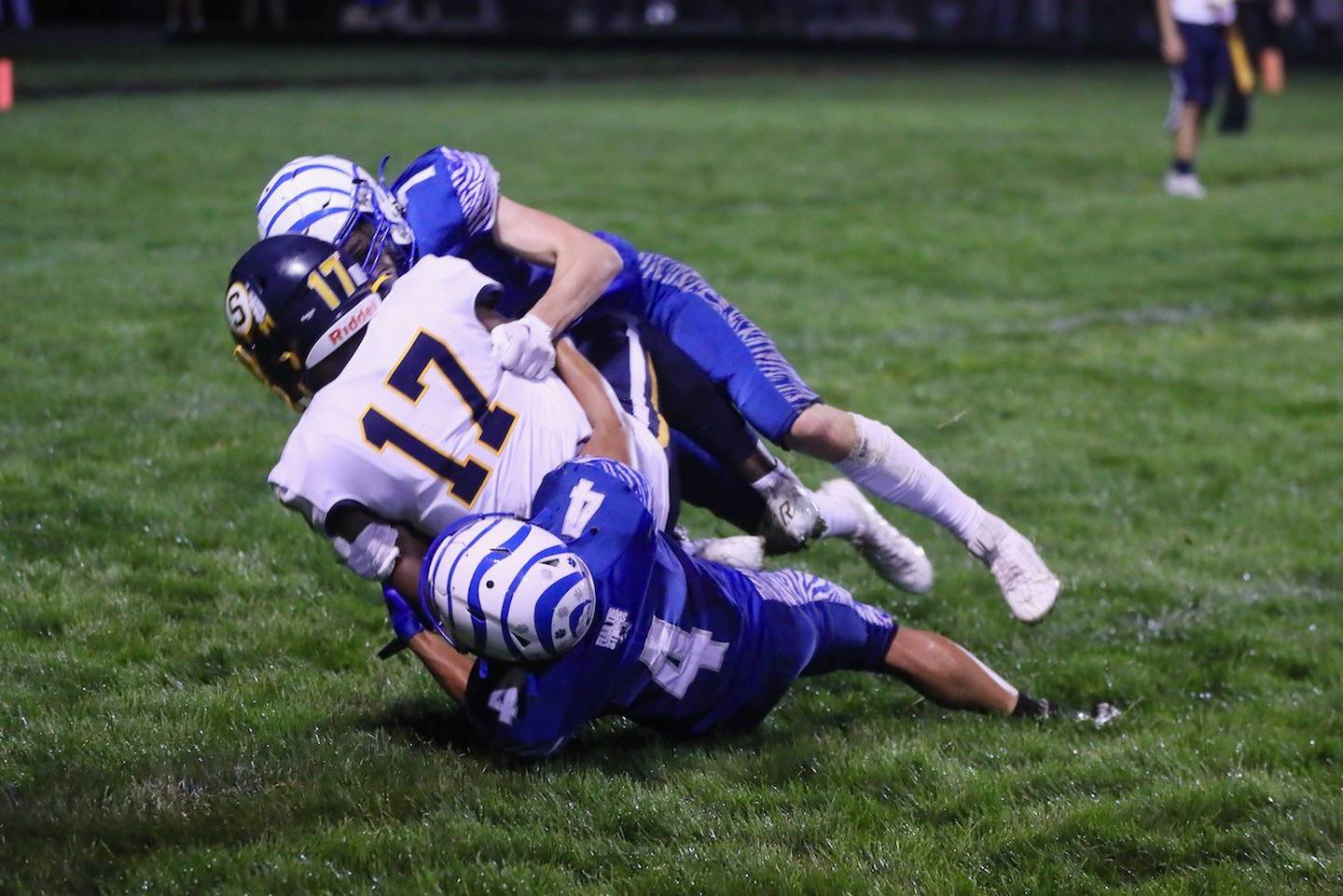 Princeton's Andrew Peacock (4) and Gavin Lanham (7) bring down Sterling's Kaedon Phillips Friday night at Bryant Field. The Tigers won 28-6.