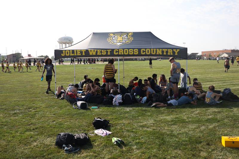 Joliet West runners shelter in the shade before the race in the Joliet West Cross Country Dual Meet against Joliet Central on Monday, Aug. 28, 2023 in Joliet.
