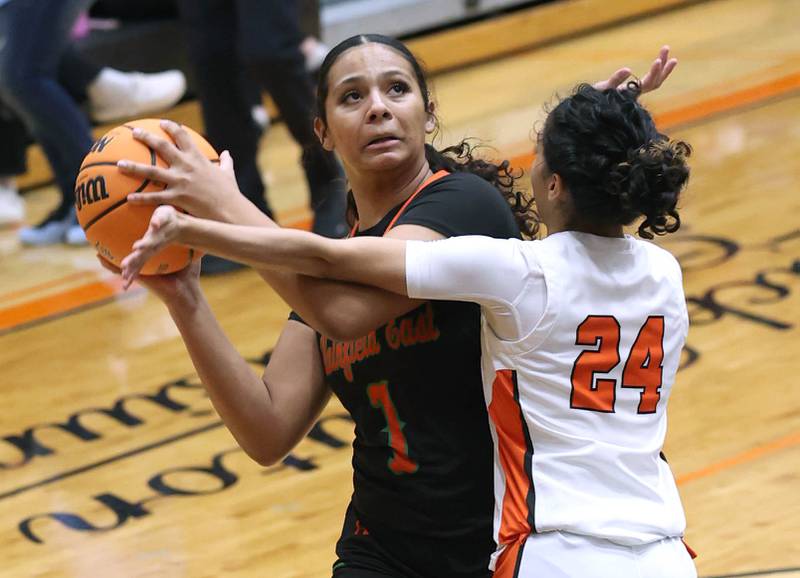 Plainfield East's Khloe Oglesby tries to get a shot up over DeKalb's Nazeria Dean Thursday, Feb. 12, 2026, during their game at DeKalb High School.