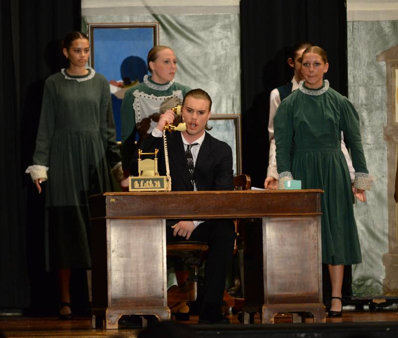 Oliver Warbucks (Dane Setterstrom) talks on the phone as he performs a scene with other cast members during Forreston High School's performance of Annie on Sunday, April 28, 2024.