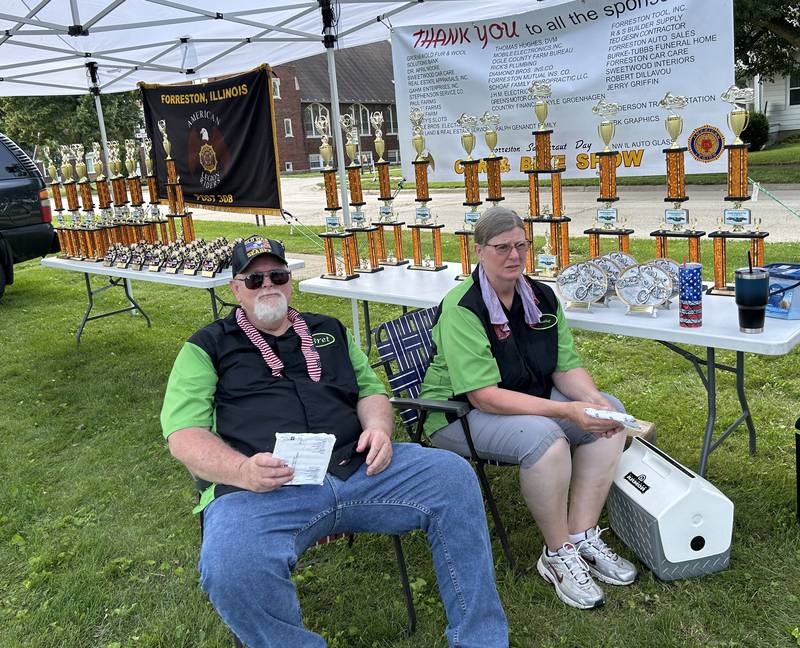 Bret and Kahy Schmel sit by the trophies for the car show at Forreston's Sauerkraut Days on Saturday, Aug. 3, 2024. The Schmels started the car show in 2009 and now are volunteers. Seventy-seven vehicles attended the show this year.