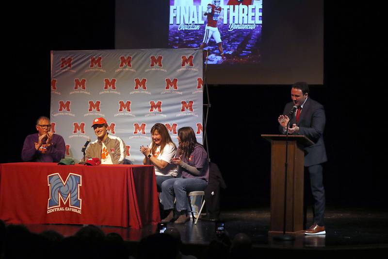 Marien Central football Coach Liam Kirwan (right) claps with Christian Bentancur’s family after Christian Bentancur announced Friday, Jan. 13, 2023, that he will attend Clemson University to play Division I football, at Marian Central High School. Bentancur, a highly recruited tight-end, narrowed his section down to Clemson from his final three colleges. The other two colleges were Ohio State and Oregon universities.