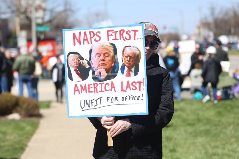 A protestor holds a Naps First America Last at the No Kings rally on Saturday, March 28, 2026 in Joliet.