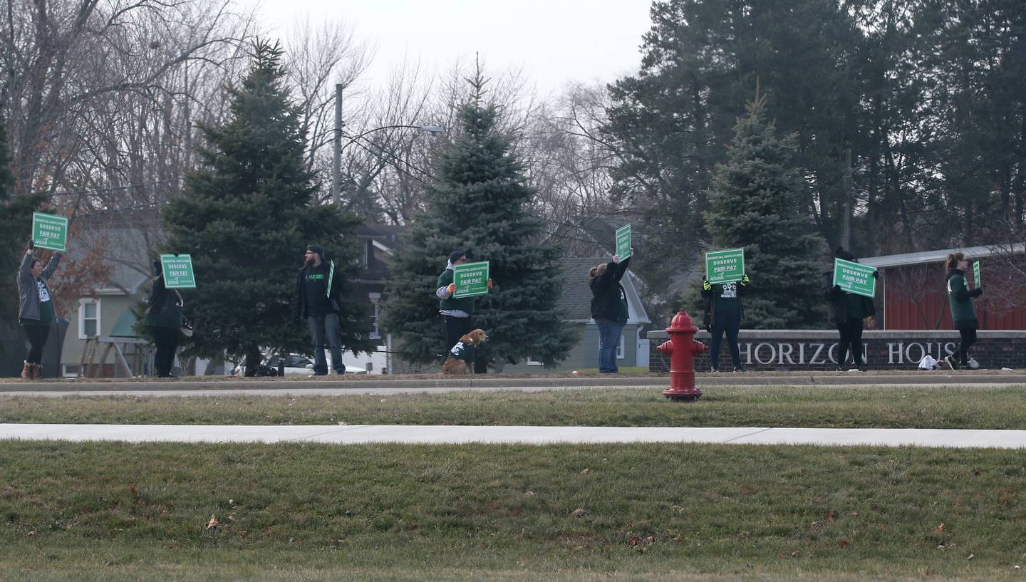 Horizon House employees hold signs reading "deserve better pay" outside of the Horizon House on Thursday, Dec. 8, 2022 in Peru.