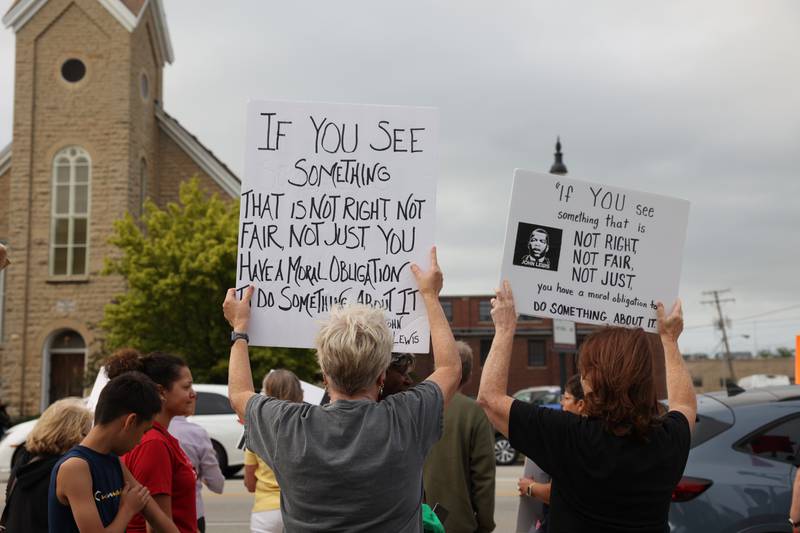 Protesters hold signs in reference to the late civil rights leader and congressman John Lewis during a "Good Trouble Lives On" rally held in Kankakee as part of a national day of peaceful protests on Thursday, July 17, 2025.