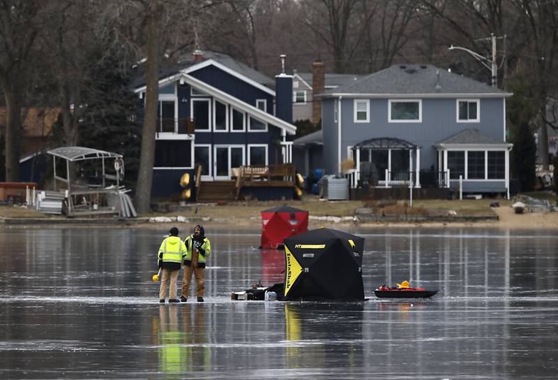 Fishermen talk while ice fishing on Wednesday, Jan. 8, 2025, on the westside of Crystal Lake near the Lakewood Village Hall.