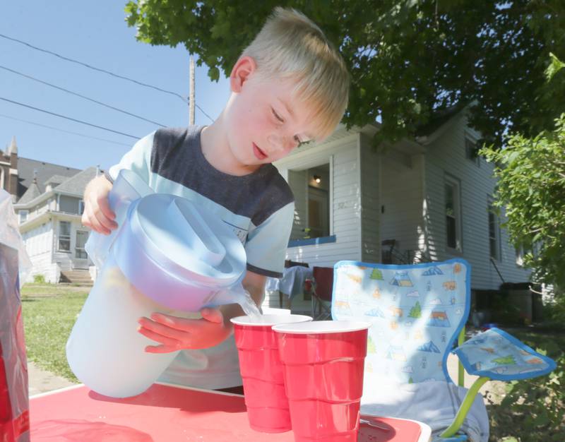 Jaxon Binder 5, of La Salle, pours a glass of lemonade at his lemonade stand Monday, June 20, 2022, in the 500 block of Crosat Street in La Salle. Binder told his mother Sierra he wanted to raise money for a new drone and set up a lemonade stand to help raise funds for it.