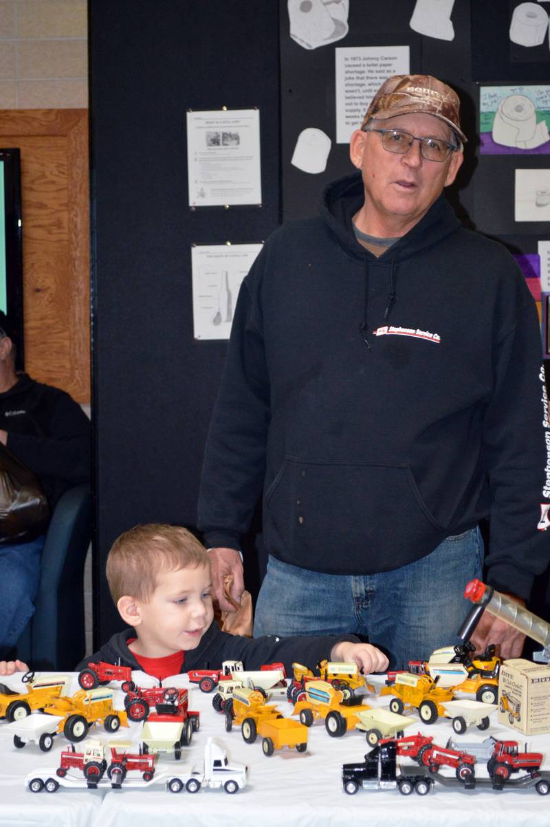 Jack Sasscer, 2, of Forreston, plays with model cars while his grandfather, Joe Brooks, of Forreston, keeps an eye during the Polo Lions Club’s 38th Farm Toy Show. The event was held at Polo Community High School on March 4.