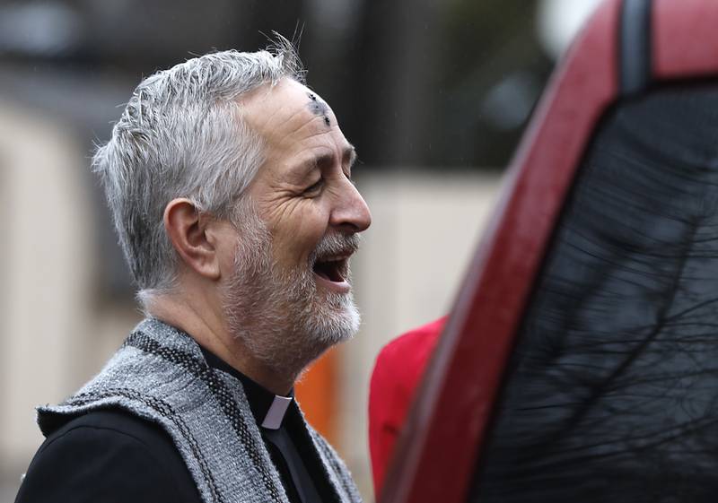 Rev. Jeffry Bross, the senior pastorat the United Methodist Church of Libertyville, laughs as he talks with congregant during a Drive-Thru Ash Wednesday Blessing on Wednesday, March 05, 2025, at the United Methodist Church of Libertyville. This was the first time the church has offered a Drive-Thru Ash Wednesday Blessing, that created a simple convenient way for individuals to receive ashes and mark the beginning of the Lenten season.