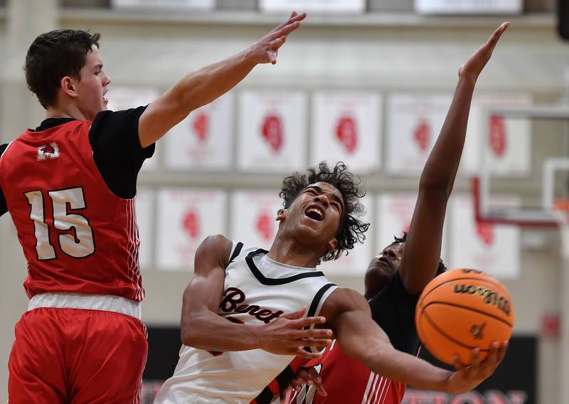 Benet’s Blake Fagbemi (middle) is fouled on his way to the basket by Marist’s Kendall Meyers (right) during a game on Friday, Dec. 13, 2024 at Benet Academy in Lisle.