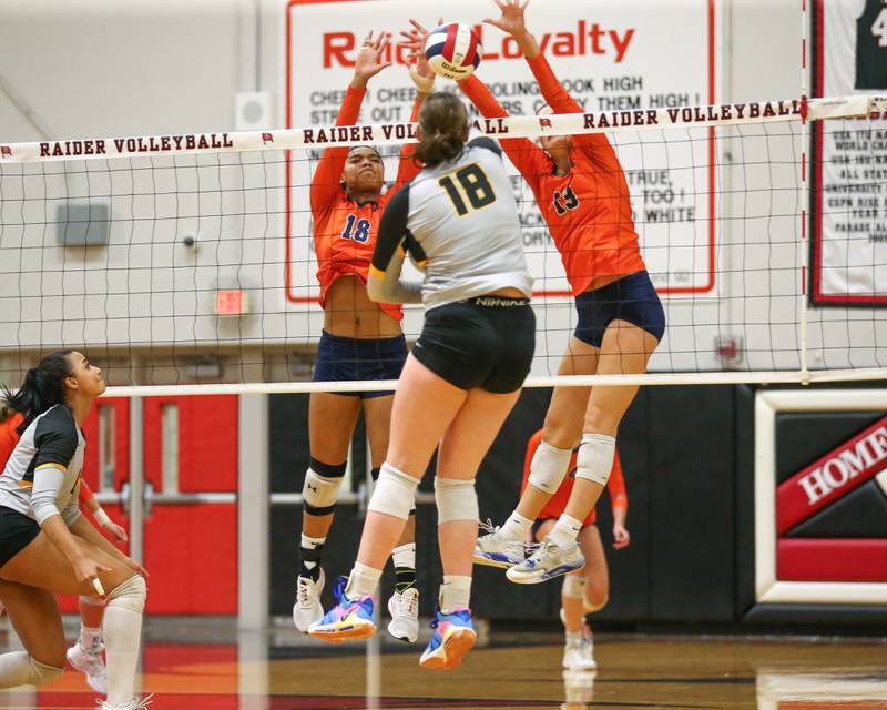 Oswego's Sidney Hamaker (13) attempts a block along with Oswego's Maya Norlin (18) at the net during Class 4A Bolingbrook Sectional semifinal match between Joliet West at Oswego.  Nov 5, 2024  in Bolingbrook.