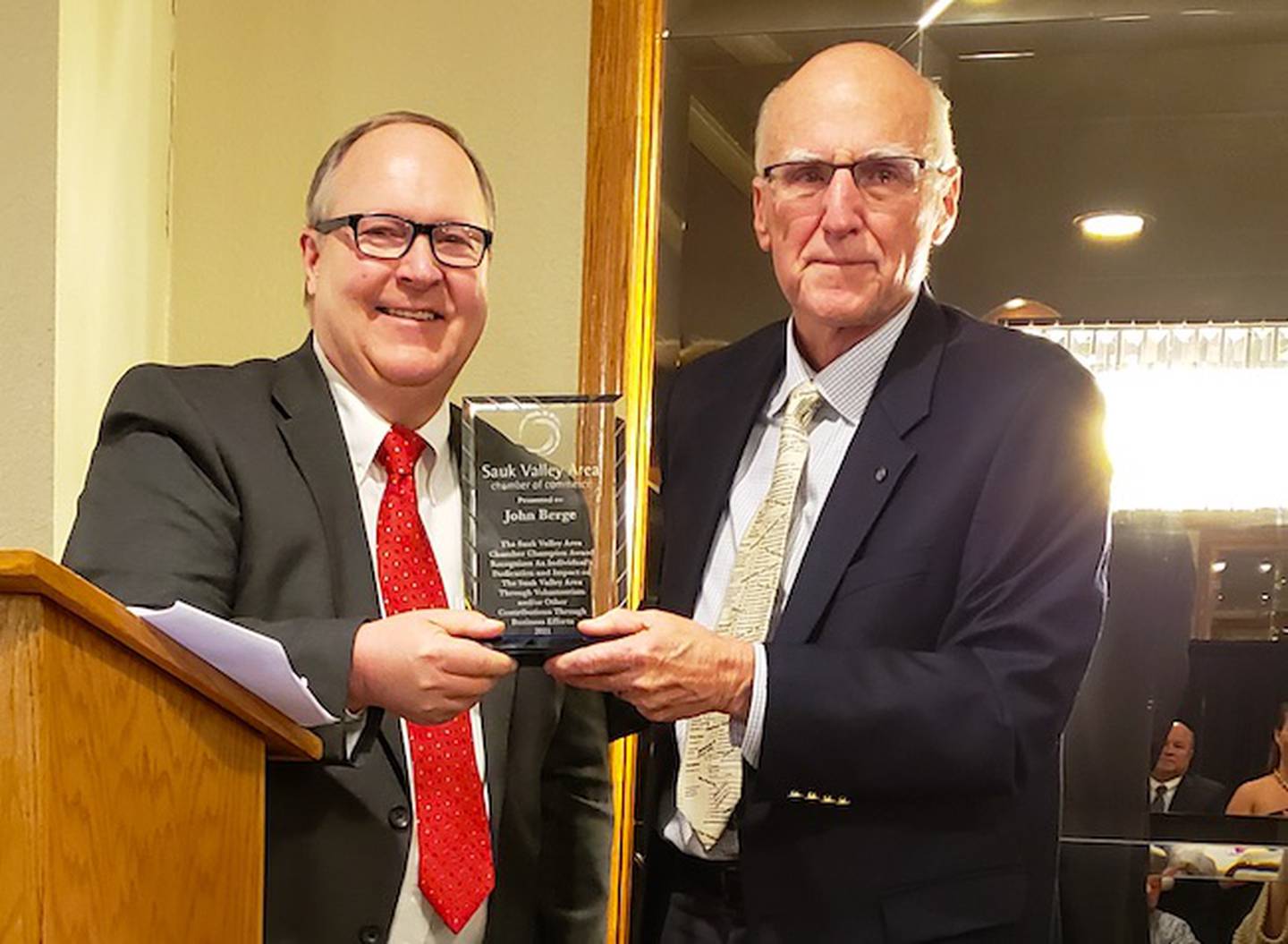Sauk Valley Area Chamber of Commerce  board member Steve Munson, left, presents John Berge with the chamber's Champion award on Thursday at the Days Inn in Rock Falls.