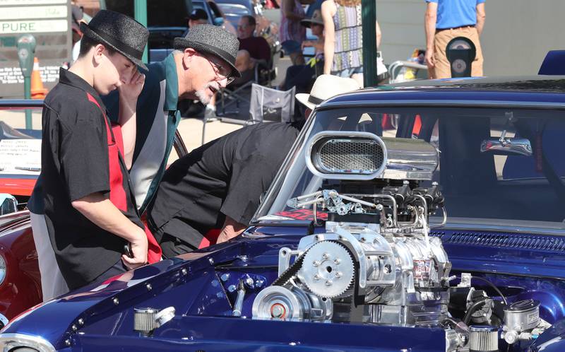 Sammy Pulia, (left) and his dad Steve, (right) from Chicago, along with his grandfather Sam Pulia, (middle) from Westchester, check out one of the cars on State Street in Sycamore Sunday, July 31, 2022, during the 22nd Annual Fizz Ehrler Memorial Car Show.