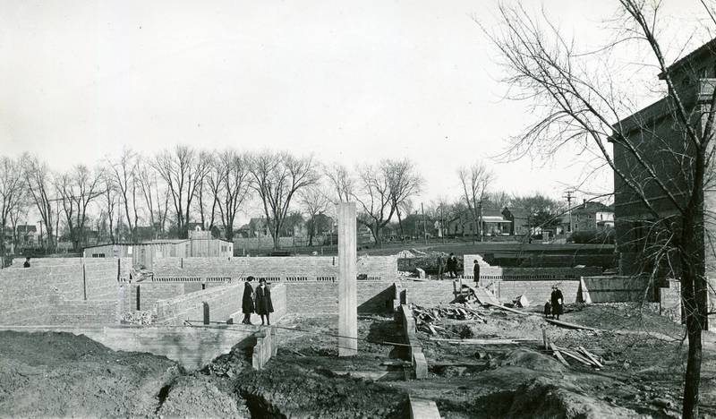 Construction on the new addition of the DeKalb Township High School began in the spring of 1922. Looking south toward Sycamore Road between First Street and Fourth Street in DeKalb, visitors inspect progress at the construction site.