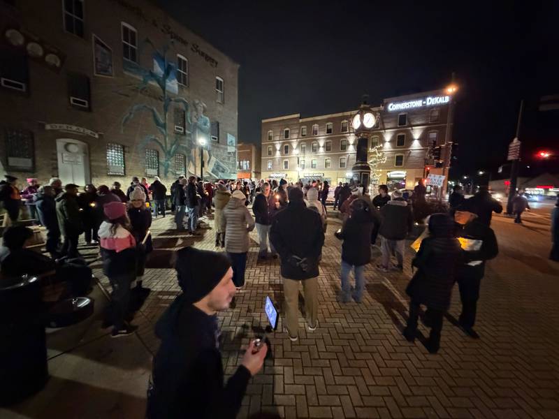 A large crowd of more than 100 people made up of men, women and youth gathers at the corner of First Street and Lincoln Highway in downtown DeKalb on Friday, Jan. 9, 2026, to remember the life of Renee Nicole Good, 37, a Minnesota mother who was shot and killed by a federal immigration agent in Minnesota on Jan. 7, 2026. DeKalb area organizers said they wanted to hold the vigil to create a safe space to mourn and call for peace amid ever-growing violence related to President Donald Trump's immigration enforcement sweeps nationwide.