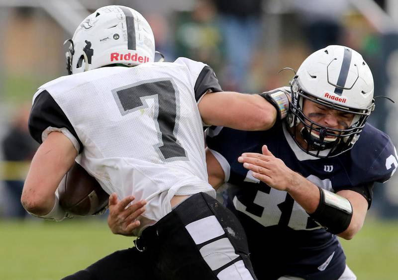 Max Buss tackles Kaneland's Wilson Gaffney during last weekend's Class 6A second-round playoff game. Buss and the Trojans face a tough challenge Saturday to contain Phillips' Jahleel Billingsley.