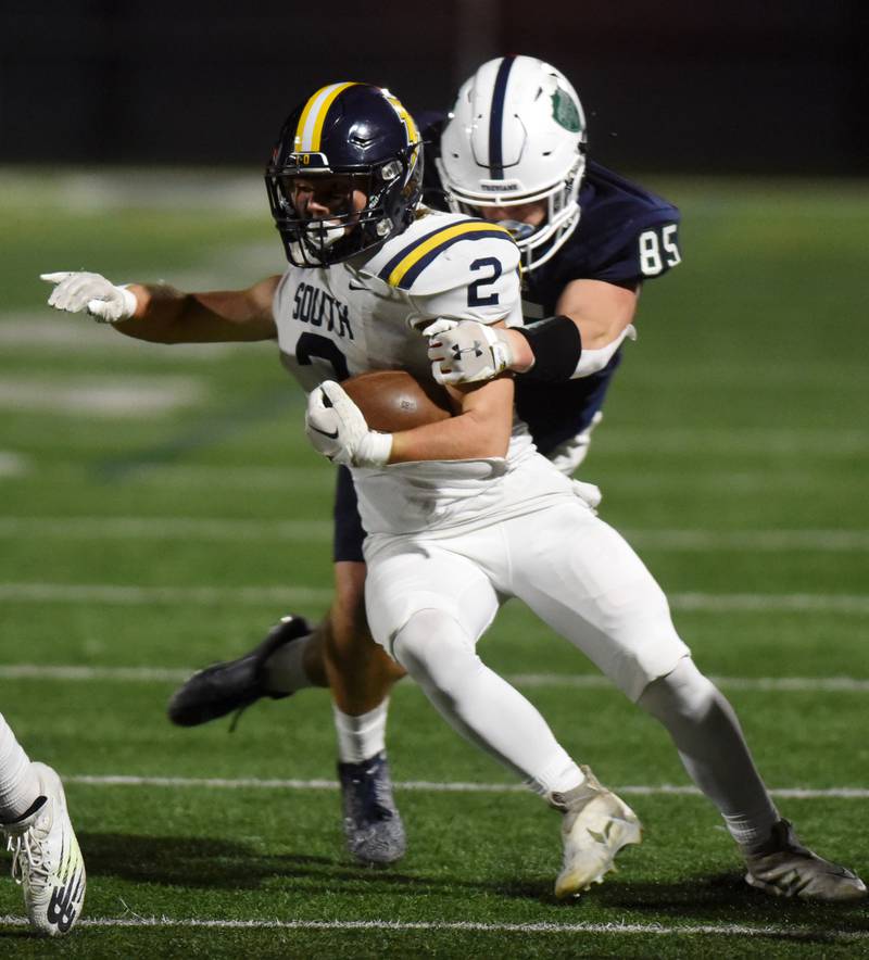 Glenbrook South's Charlie Gottfred gets tackled by New Trier's William Fitzgerald Jr. during Friday’s game in Northfield.