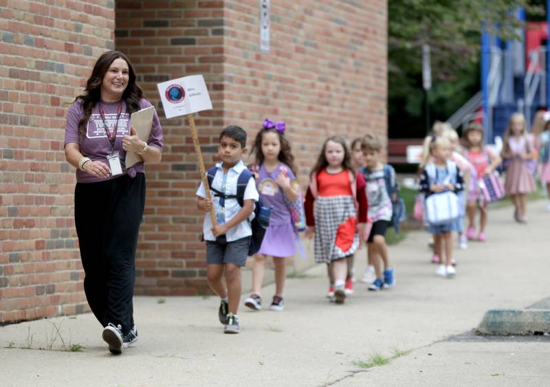 Cindy Gibson leads her kindergarten class into the building for the first day of school at Wild Rose Elementary School in St. Charles on Monday, Aug. 14, 2023.