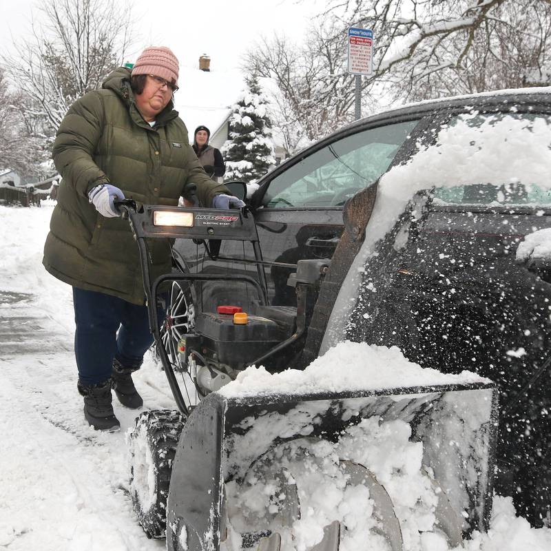 Rhonda Cioni, from DeKalb, helps her neighbor dig his car out Friday, Jan. 12, 2024, after early morning snow covered his vehicle. Several inches of snow blanketed DeKalb County Friday on top of the 6 inches that fell on the area earlier this week.