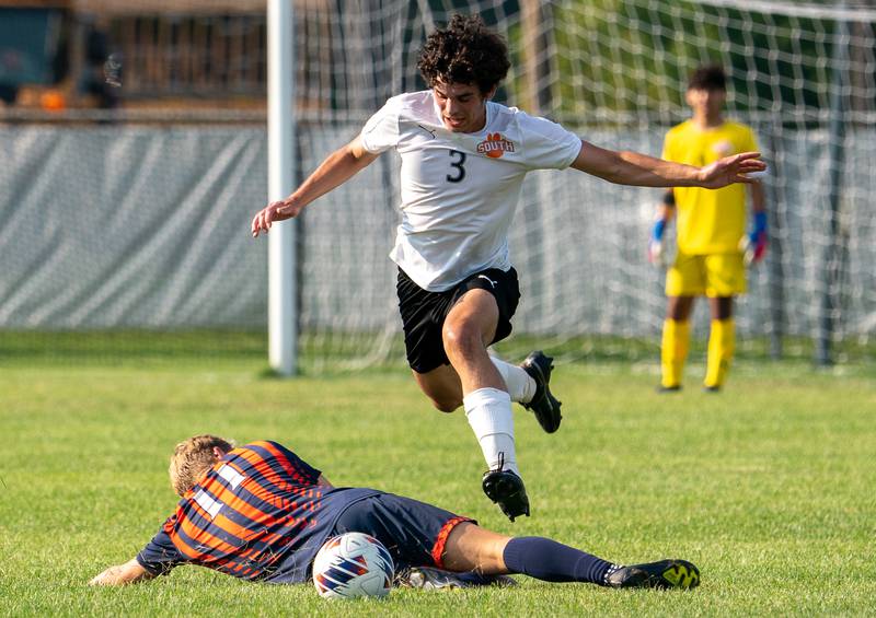 Wheaton Warrenville South's Tim Foley (3) plays the ball avoiding a slide tackle by Oswego’s Josh Nelson (11) during a soccer match at Oswego High School on Thursday, Aug 25, 2022.