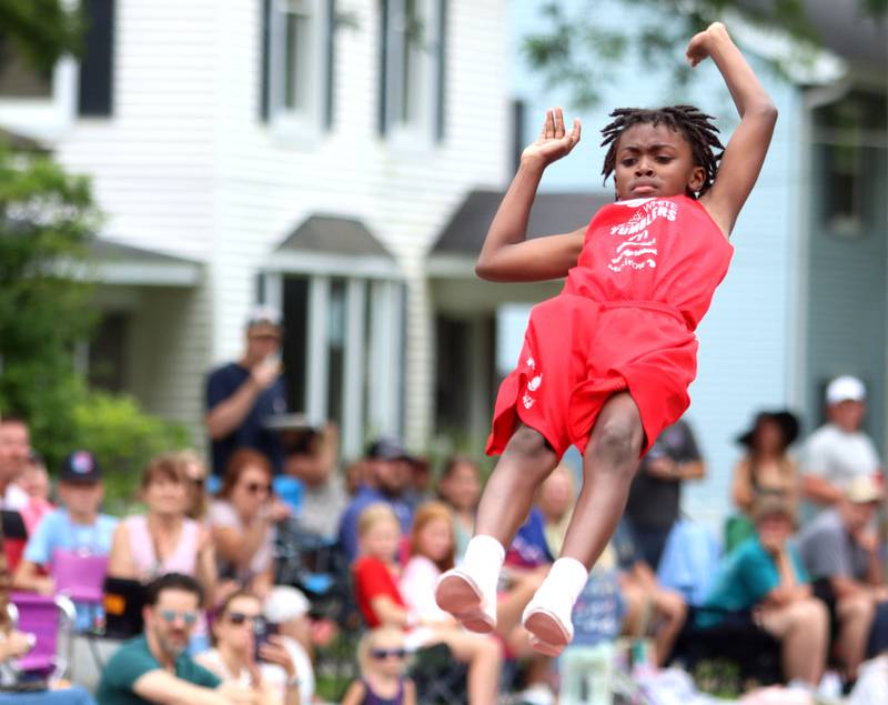 A performer  from the Jesse White Tumblers flies through the Fiesta Days Parade down Main Street in McHenry on Sunday, July 20, 2025.