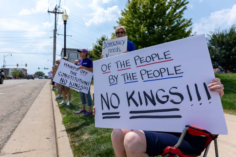 Protesters hold signs at the “No Kings” protest on Saturday,  August 9, 2025 at Rotary Park in Princeton.