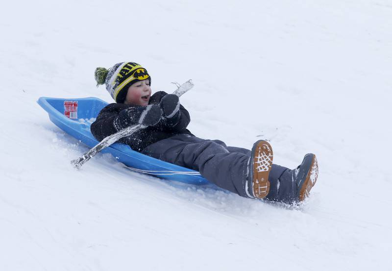 Grady Perocho, 5, of Crystal Lake, uses a stick to guide his sled while sledding at Veteran Acres Park the afternoon of Monday, Jan. 24, 2022, after McHenry County received a fresh snowfall.