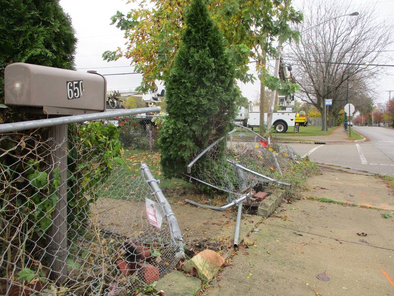 Ripped-up chain-link fence shows the path of a SUV driven by a man killed by gunfire on Henderson Avenue in Joliet on Sunday. Oct. 31, 2022.