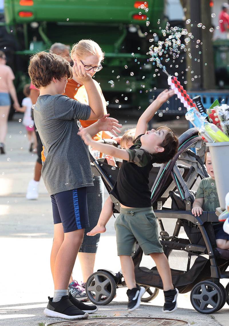 Kids play with bubbles at one of the booths Friday, Aug. 26, 2022, during Corn Fest in downtown DeKalb.
