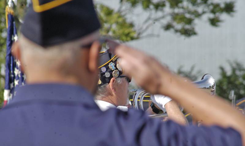 Rock Falls Legion Commander John Roush plays taps as a veteran salutes. Rock Falls American Legion Post 902 hosted a ceremony at Lower Dam Park in Rock Falls. The event took place Monday, May 26.