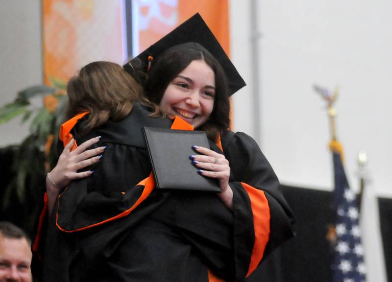 Lilliana Benitez is hugged after receiver her diploma Saturday, May 21, 2022, during the McHenry High School 102nd Commencement Ceremony in the gym of the school’s Upper Campus. The ceremony was moved inside and split into two ceremonies because of the rainy weather.
