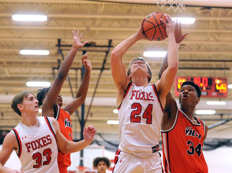 Yorkville's Caleb Fisher (24) powers a shot for a score against Romeoville defender Kaharie Loggin (34) during a boys' basketball game at Yorkville High School on Tuesday, Jan. 10, 2023.