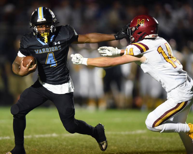 Joe Lewnard/jlewnard@dailyherald.com
Maine West’s Onell Miller-Smith stiff-arms Scahumburg’s Trey Teschner during Friday’s game in Des Plaines.