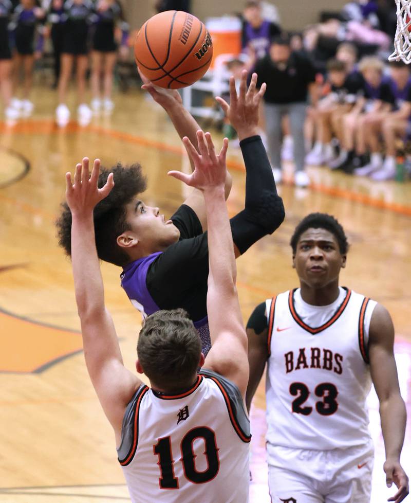 Dixon’s Darius Harrington shoots over DeKalb’s Eric Rosenow during their game Tuesday, Dec. 12, 2023, at DeKalb High School.