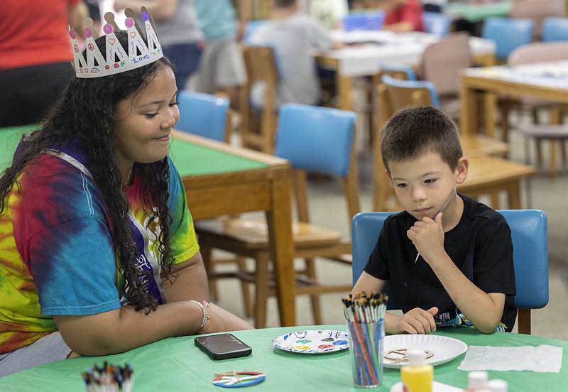 Jorge Smith, 7, of Dixon contemplates his color choices while working on a craft with Petunia Queen Tya Collins on Wednesday, July 3, 2024, at the Dixon library. Petunia Fest is officially underway.
