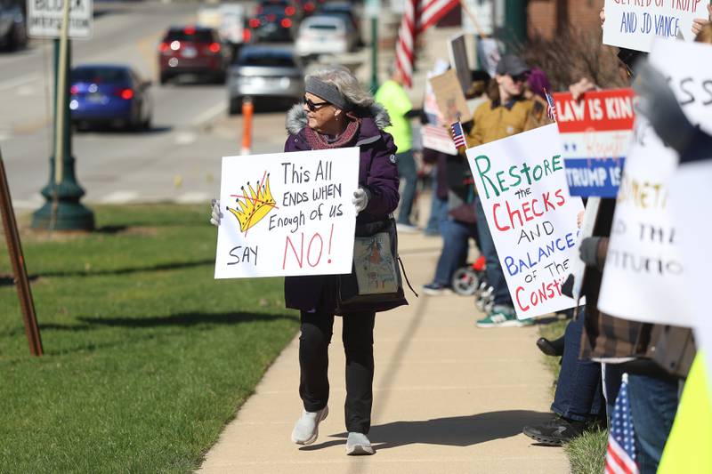 A protestor carries a sign along East 9th Street at the No Kings rally on Saturday, March 28, 2026 in Lockport.