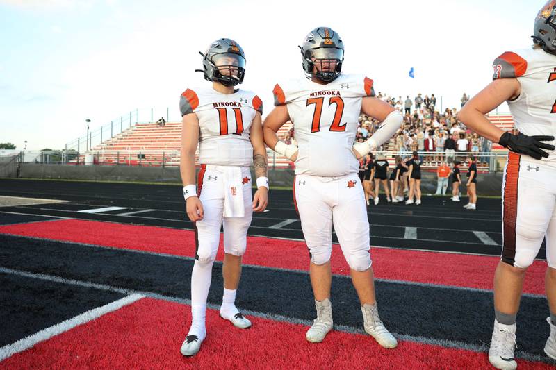 Minooka’s Gavin Dooley (11) and Ryan Susnar (72) stand on the sidelines between series against Bolingbrook. Friday, Aug. 26, 2022, in Bolingbrook.