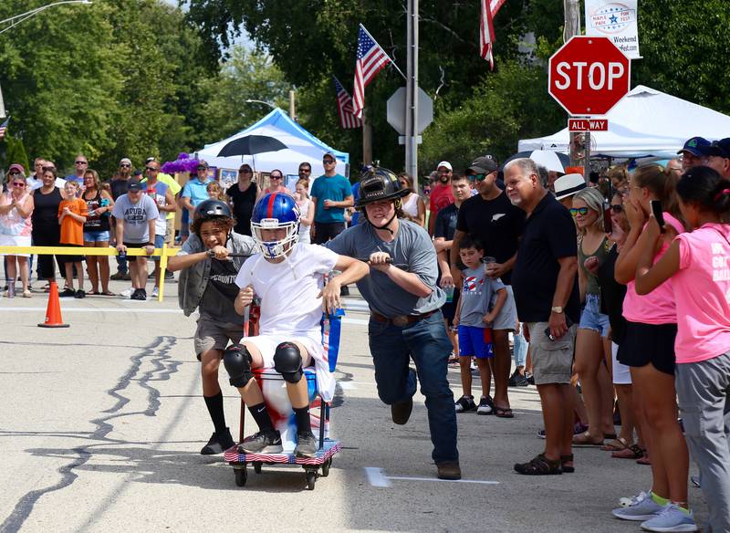 Team USA (l-r) Jacob Duncan, Isaac Gramley and Sawyer Loebbaka participate in the Toilet Bowl Races at the Maple Park Fun Fest on Saturday, Sep. 3, 2022.